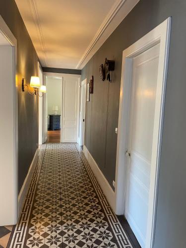 a hallway with a black and white tile floor at La maison des douceurs in Bussang