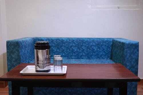 a coffee maker on a table on a blue couch at Amrit Hotel in New Delhi