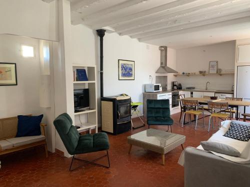 un salon avec un canapé et des chaises et une cuisine dans l'établissement Coquillage bleu, à Six-Fours-les-Plages