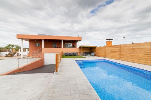 a house with a swimming pool next to a fence at Piscina de sal Barbacoa Wifi, Parking Gratis, 3 min PGA Casa El Roble in Girona