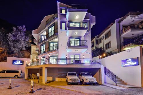 two cars parked in a parking lot in front of a building at Carpediem Apart in Kas
