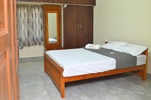 a bedroom with a large bed with white sheets at Live Inn JP Nagar in Tiruchchirāppalli