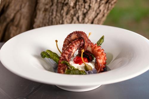 a white bowl of food with a shrimp in it at Le Lenze Don Mimì Glamping in Mattinata