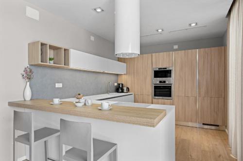 a kitchen with white and wood cabinets and a counter at Villa Moon near the sea in Fažana