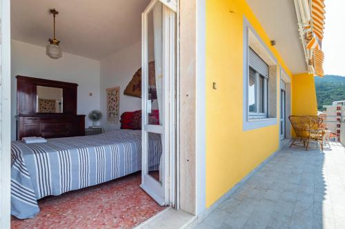 een slaapkamer met een bed en een gele muur bij Blumele Lovely Sea View Apartment in Deiva Marina