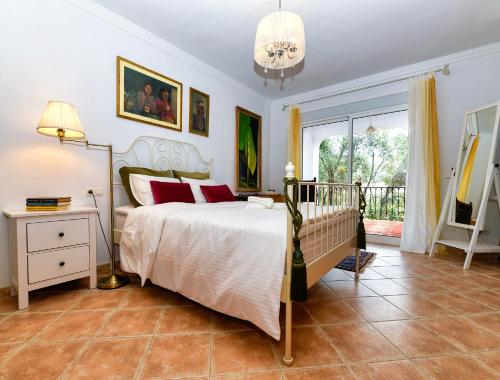 1 dormitorio con cama y ventana grande en Villa Mira Monda, en Monda