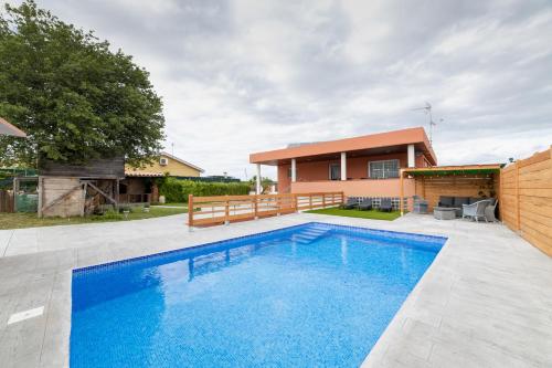 una piscina frente a una casa en Piscina de sal Barbacoa Wifi, Parking Gratis, 3 min PGA Casa El Roble, en Girona