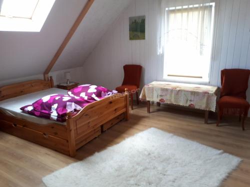 a bedroom with two beds and two chairs and a window at Dom letniskowy Puńsk in Puńsk