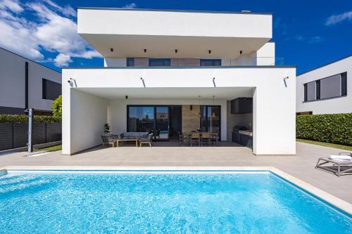a villa with a swimming pool in front of a house at Villa Moon near the sea in Fažana