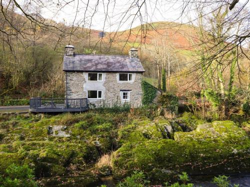 a stone house in the middle of a field at Pen y Bont in Machynlleth