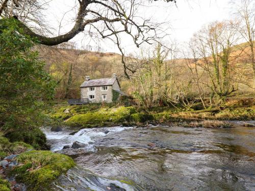 a house on a hill next to a river at Pen y Bont in Machynlleth