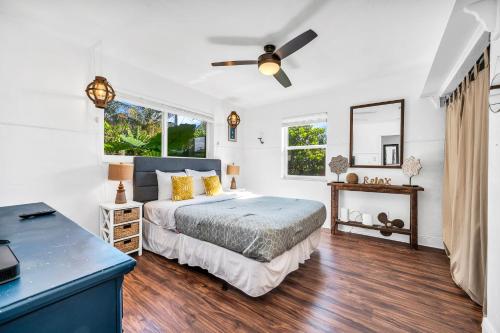 a bedroom with a bed and a ceiling fan at Tropical Waters Hideaway - Pool Tiki & Lounge in Pompano Beach