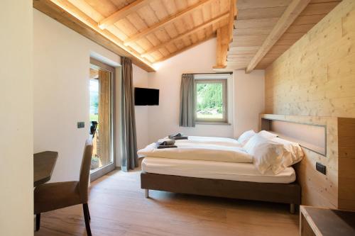a bedroom with a bed and a desk and a window at Agriturismo Bosco d'oro 2 in Livigno