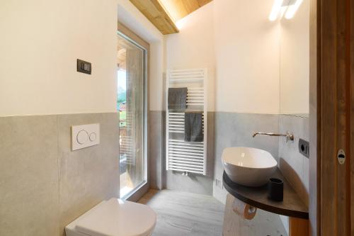 a bathroom with a sink and a toilet and a window at Agriturismo Bosco d'oro 2 in Livigno