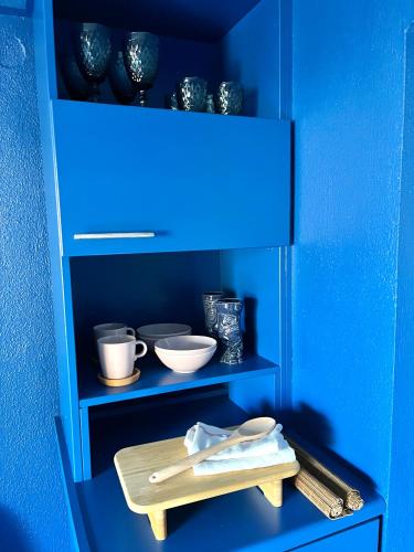 a blue shelf with bowls and utensils on it at Costal apartment in Glyfada