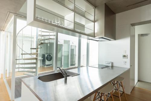 a kitchen with a large sink and a staircase at 湘南OCEAN HOUSE in Koshigoe