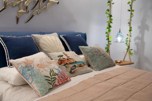 un grupo de almohadas sentadas en una cama en San Nicolicchio - Luxury Guest House, en Taranto