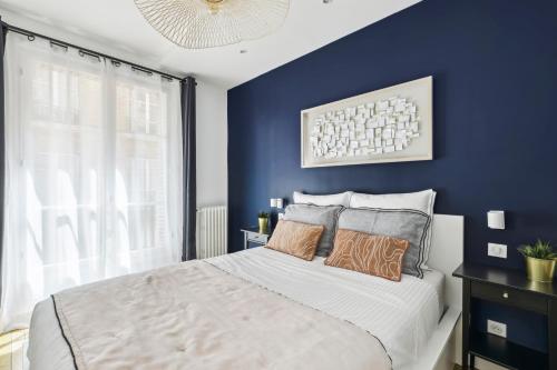 - une chambre avec des murs bleus et un lit avec des oreillers dans l'établissement Luxury near Monceau & Wagram, à Paris