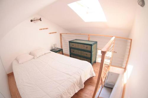 Dormitorio en el ático con cama y escalera en maison la rochelle quatres chambres bord de mer, en La Rochelle
