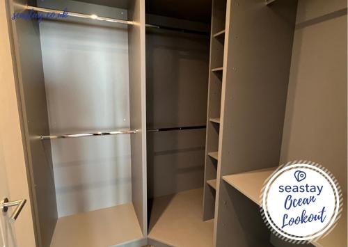 a walk in closet with a stainless steel refrigerator at Ocean Lookout- 3 Bed Sea View Apt Parking No Fees in Kent