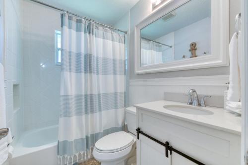 a bathroom with a sink and a toilet and a mirror at Enchanting Juno Beach Home! Sleeps 8! in West Palm Beach