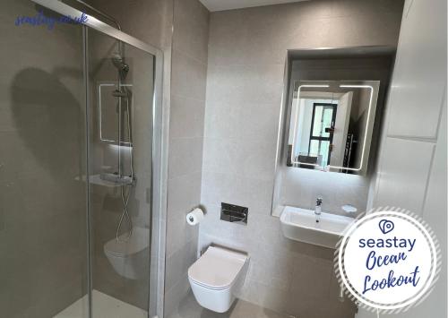 a bathroom with a shower and a toilet and a sink at Ocean Lookout- 3 Bed Sea View Apt Parking No Fees in Kent