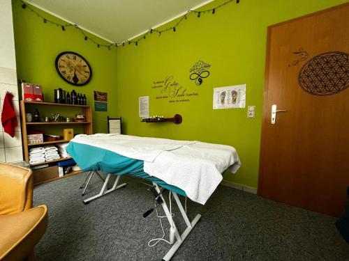 um quarto de hospital com uma mesa num quarto com paredes verdes em Feriendorf Waldfrieden em Suhl