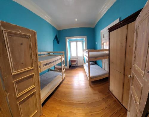 a room with two bunk beds and blue walls at The Pink House in Faja Grande