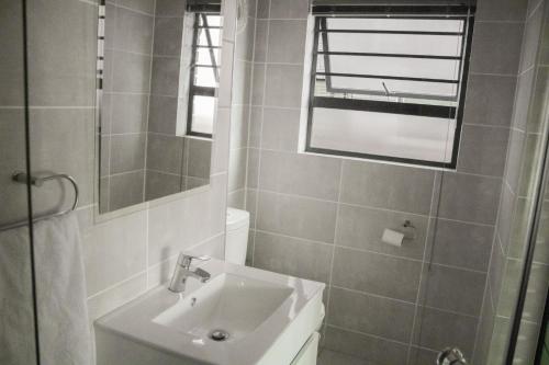 a bathroom with a sink and a mirror at 1517 The Blyde Crystal Clear 3 Bedroom Garden Beachfront in Pretoria