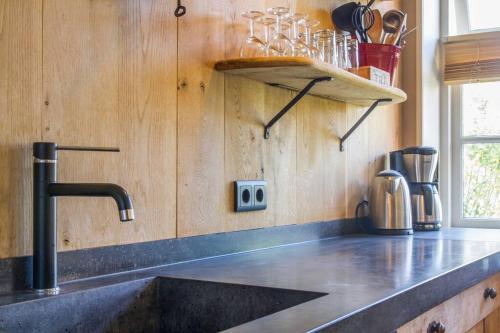 een keuken met een wastafel en een aanrecht bij Appartement Atmospheria in romantische stolp in Warmenhuizen