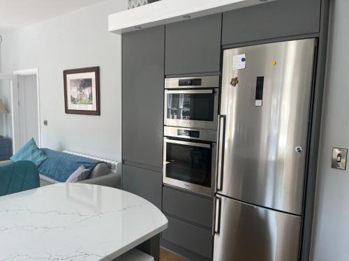 a kitchen with a stainless steel refrigerator and a table at Wellington Cottage in Wexford