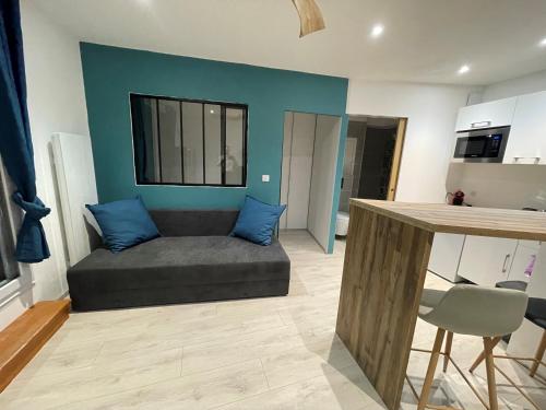 un salon avec un canapé avec des coussins bleus dans l'établissement Appartement T2 moderne au cœur des Minimes, à La Rochelle