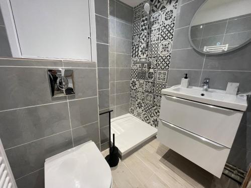 une salle de bain avec des toilettes blanches et un lavabo dans l'établissement Appartement T2 moderne au cœur des Minimes, à La Rochelle
