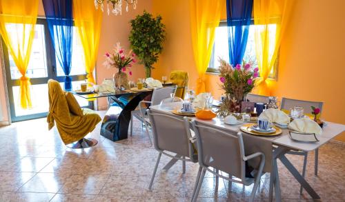 a dining room with a table and chairs and windows at Residência Vitória de São Marcos in Trancoso