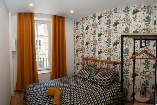 ein kleines Schlafzimmer mit einem Bett und einem Fenster in der Unterkunft Joli appartement F2 plein centre Coutances in Coutances