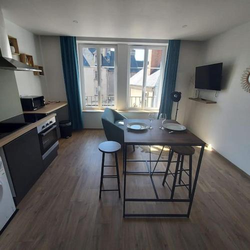 cocina con mesa y 2 taburetes en una habitación en Joli appartement F2 plein centre Coutances, en Coutances