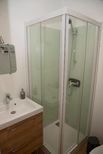 ein Bad mit einer Glasdusche und einem Waschbecken in der Unterkunft Joli appartement F2 plein centre Coutances in Coutances