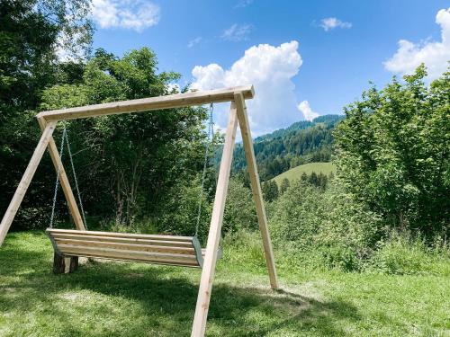 a wooden swing in a field of grass at Gasthof Arriach in Arriach