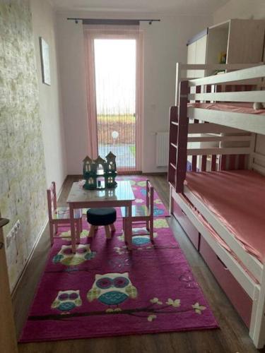 a room with a table and a bunk bed at Balatonra néző, gyerekbarát. in Fonyód