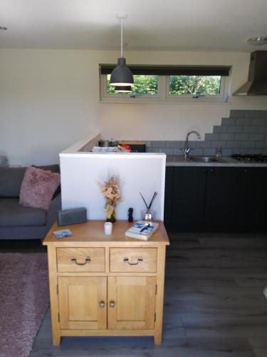 a living room with a table and a kitchen at Lake District and Eden Valley Thornhill Lodge in Long Marton