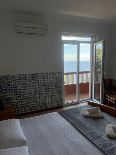 1 dormitorio con cama y ventana grande en Budva Metaxi Suits en Budva