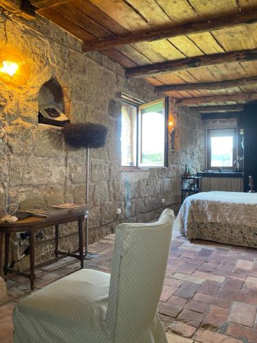a bedroom with a bed and a table and a chair at officina alchemica in Calcata