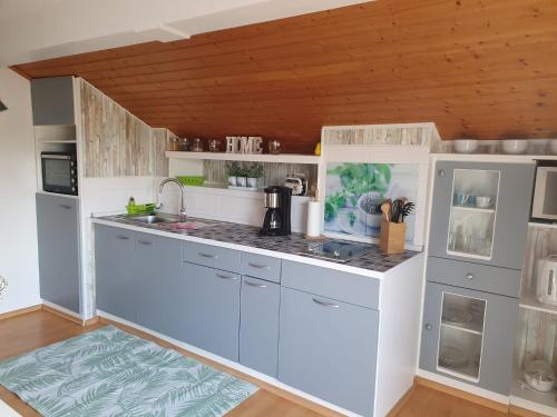 a kitchen with white cabinets and a counter top at Ferienwohnung Langdorf in Langdorf im Landkreis Regen