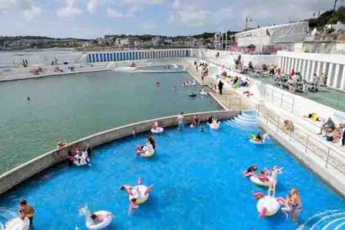 a group of people in a pool at a water park at Very Spacious, Great location. Castle and Sea view in Marazion