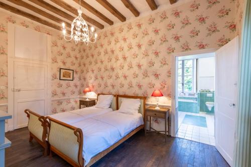 1 dormitorio con cama y lámpara de araña en Château de la Marronnière, en Aizenay