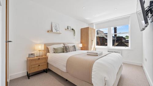 een witte slaapkamer met een groot bed en een raam bij Host & Stay - Lark Lane Hideaway in Liverpool