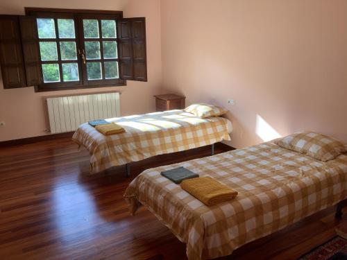 two beds in a room with wood floors and windows at The living mountain 