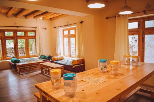 Cette chambre dispose d'une table en bois avec des verres. dans l'établissement Raybo Hostel, à Leh