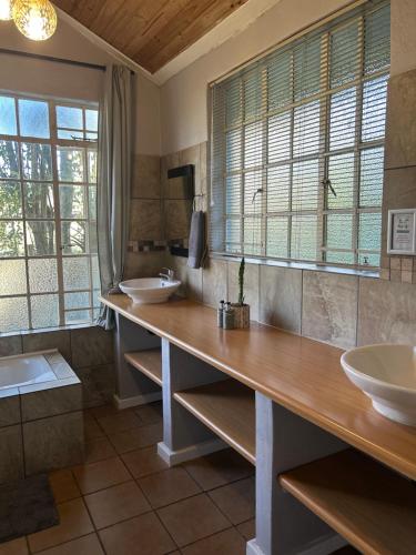 a bathroom with two sinks and a large counter with mirrors at Sabie Self Catering Apartments in Sabie