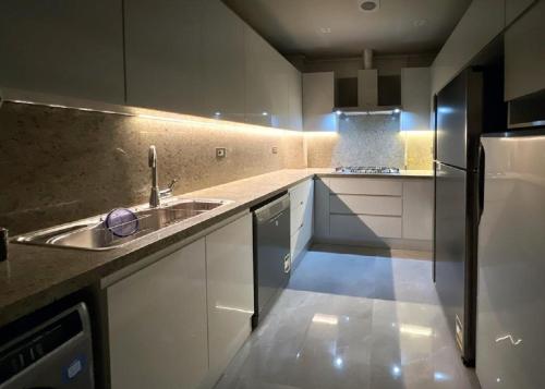uma cozinha com um lavatório e um frigorífico em شقه فندقية بالشيخ زايد em Sheikh Zayed